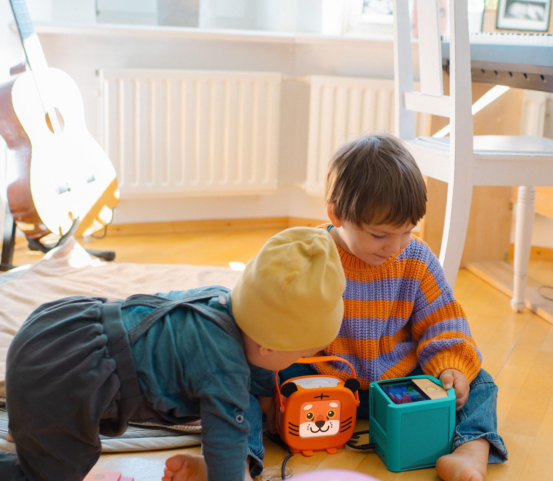 Zwei Brüder sitzen auf dem Boden und beschäftigen sich mit der tigerbox MINI und der tigerbox TOUCH.